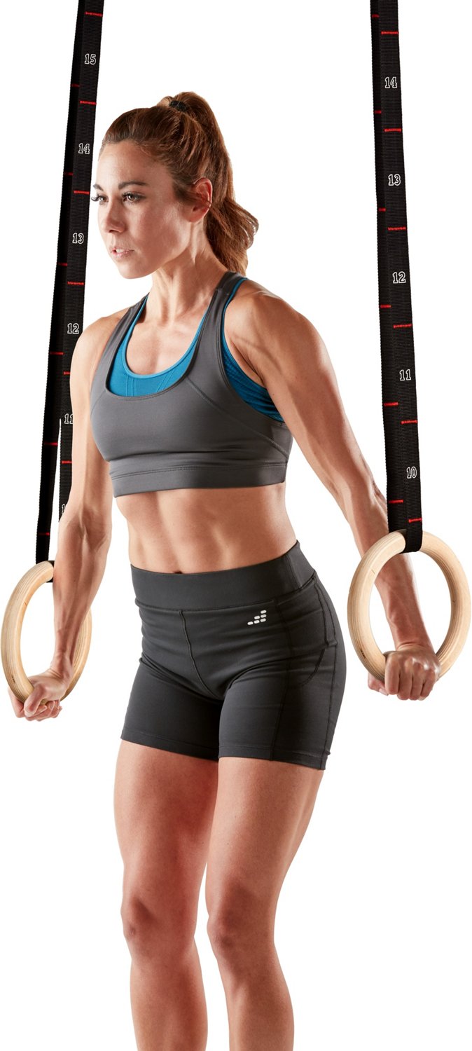 Sporty woman using gymnastic rings/ Sporty women in a gym